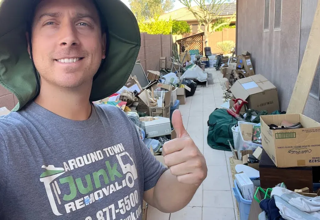 A crew member beside a patio packed with boxes and furniture on an Anthem garage cleanout