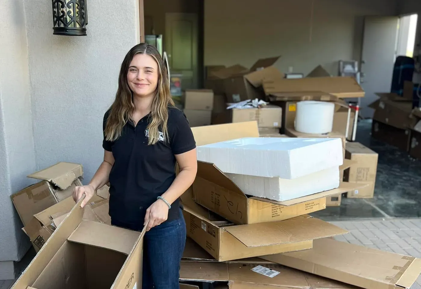 A crew member breaking down moving boxes and packing foam at a Desert Mountain home