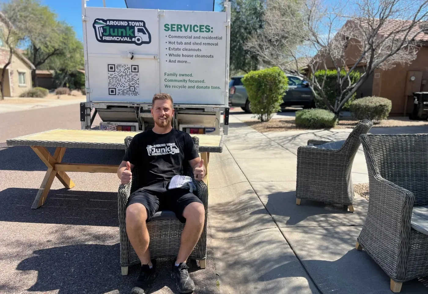 A crew member seated in one of the wicker patio chairs being hauled from a Desert Ridge home