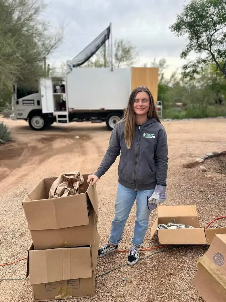 A crew member with flattened cardboard beside the truck on a Scottsdale job