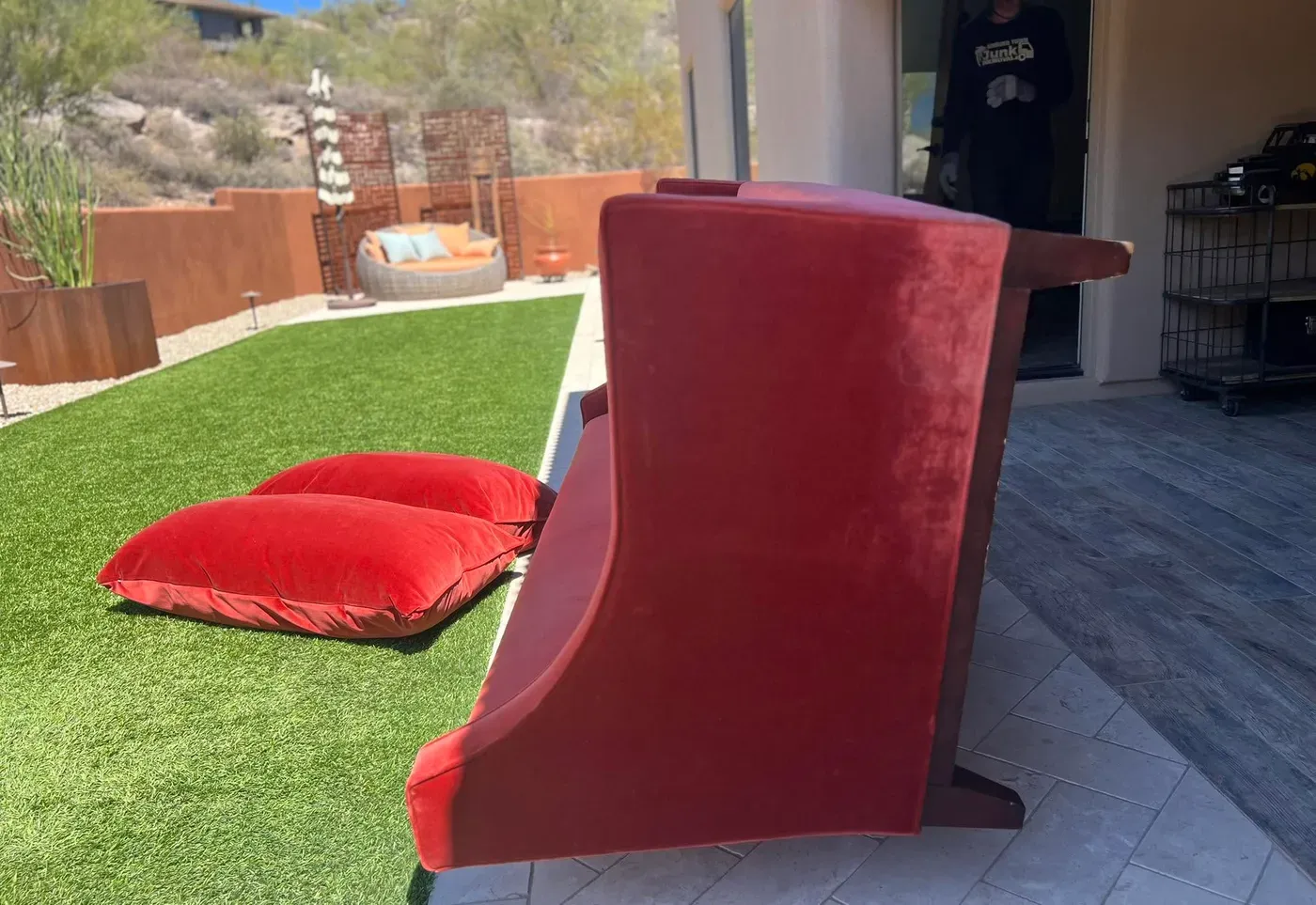 A red velvet couch carried out of a Whisper Rock casita onto the lawn