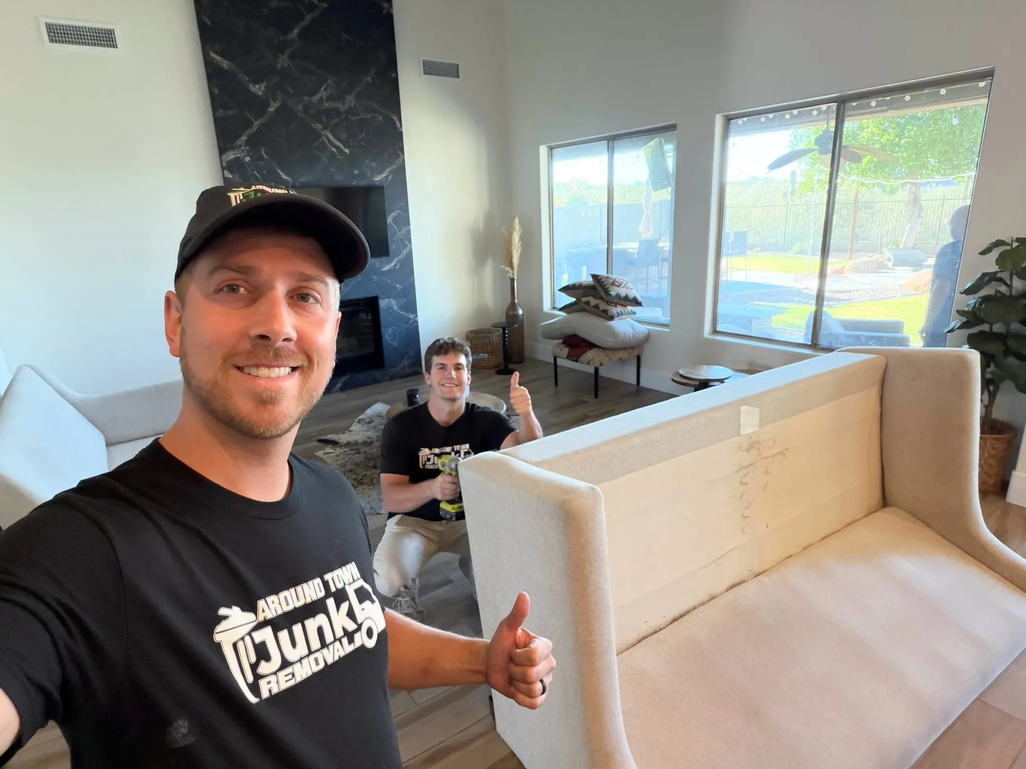 Crew removing a sofa from a staged Phoenix living room