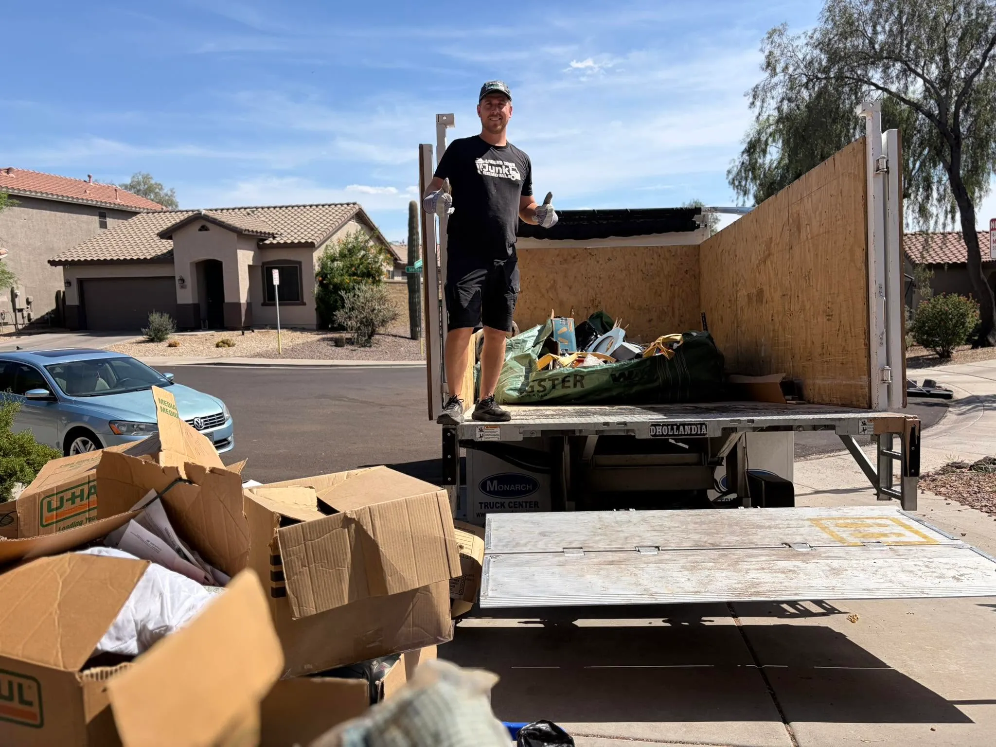 Crew member on the truck bed loading boxes at a Phoenix home